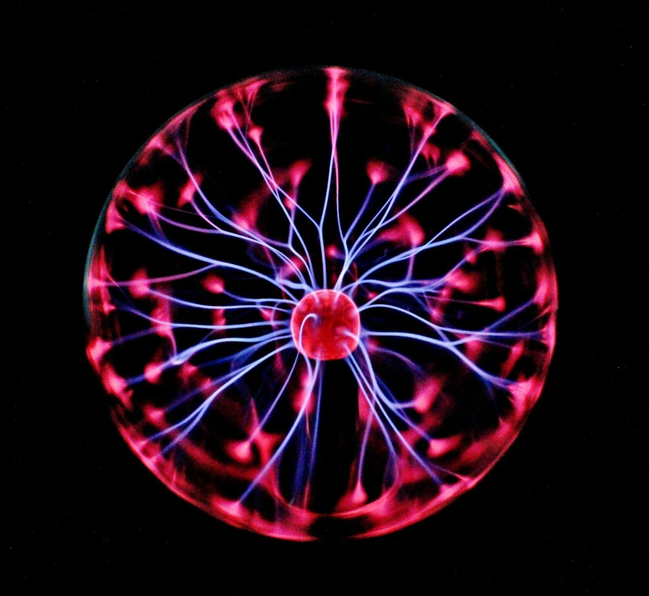 service-05 Close-up of a plasma globe with vibrant neon sparks against a dark background.
